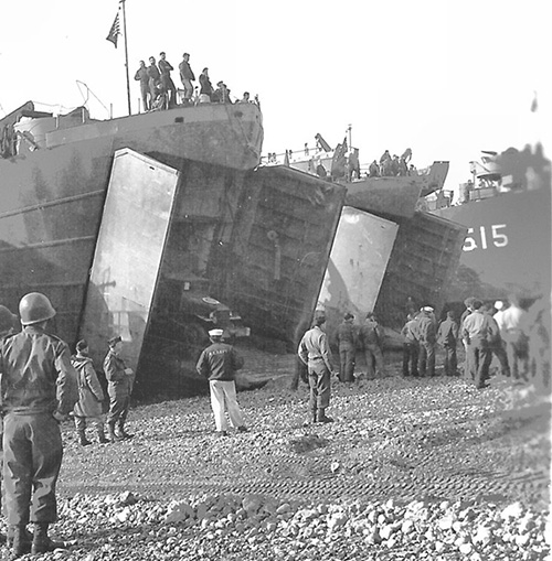 lst-515 USS LST-515, an unidentified LST and USS LST-54 beached, date and location unknown. LST-54 is unloading a truck.