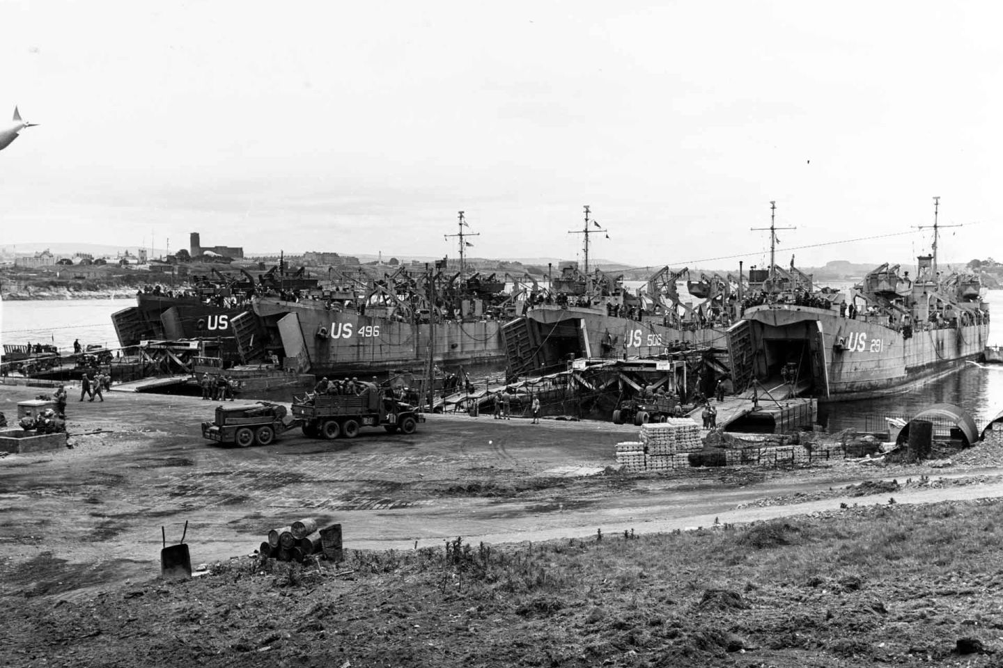 Four LST's take vehicles aboard during pre-invasion loading operations at an English port. USS LST-496 is second from the left.