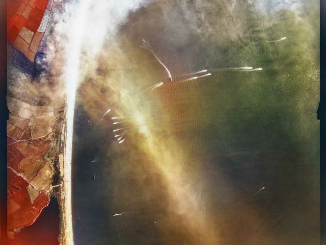 Colourised USAAF aerial view image of Exercise Tiger by about 09:00 on the morning of 27 April 1944. The patchy clouds are the remains of the smokescreen, obscuring the naval bombardment target areas. Tanks are scattered on the slope of the beach. More Landing Craft Vehicle/Personnel are on their final approach to the beach and at least 8 are returning to their transport ships. Image Source: <a href="https://historicengland.org.uk/images-books/archive/collections/photographs/usaaf-collection-exercise-tiger/" target="_blank" alt="Click this link to visit the Historic England website Witnessing Exercise Tiger: USAAF Photos from April 1944 section with more information about the image collection in a new browser tab or window.">Historic England Archive</a>. USAAF Photography.